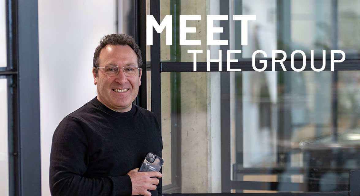 Denys Poulet is standing in an open-plan office at the Brüning Group, holding a work mobile phone